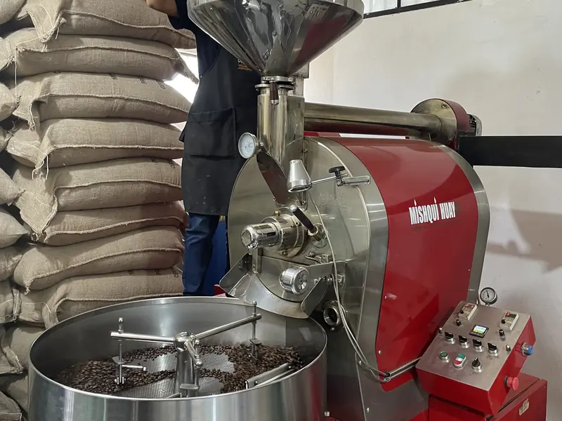 Tostadora roja con granos en el enfriador